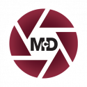 ONEMcDonough A maroon circular logo with segmented lines resembling a camera shutter, featuring the letters McD in bold black text at the center.