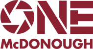 ONEMcDonough Logo with the word ONE, where the O resembles a camera shutter, and McDONOUGH in bold red text below.