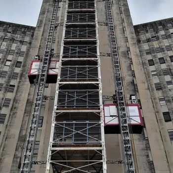 ONEMcDonough A tall building facade with construction scaffolding and two temporary elevator platforms on either side, showcasing the use of construction equipment rentals.